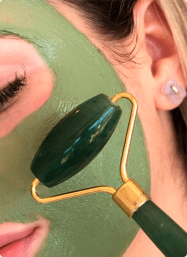 A woman with green face mask and gold ear cuff.