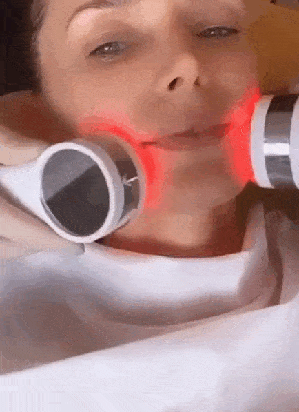 A woman with red light on her face.